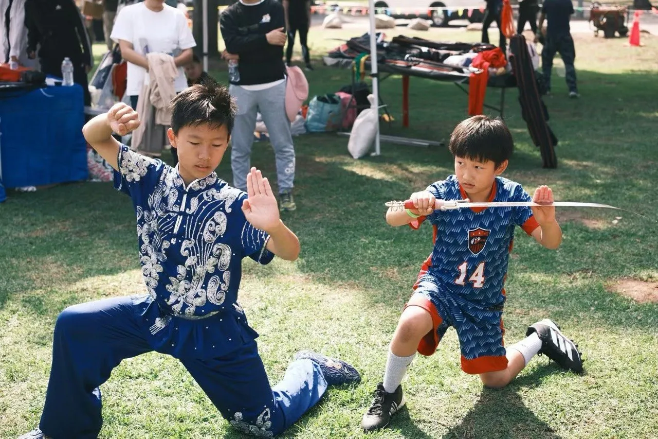 A wushu student and a young athlete strike poses at the festival.
